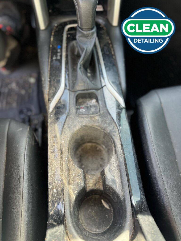 The before photo of the clean center console of a vehicle before a car detailing appointment at Clean Car Wash and Detail in Fredericksburg, VA.