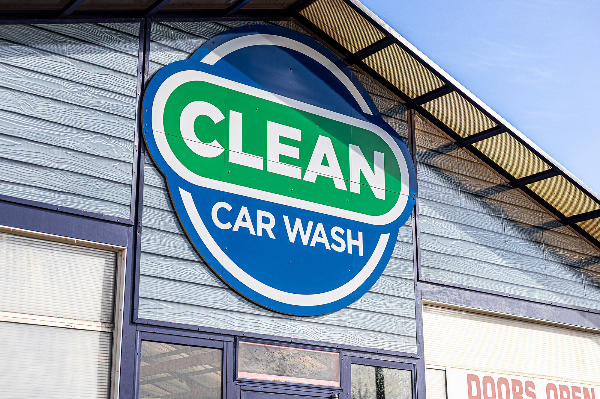 A photo of the Clean Car Wash logo emblem on the facade of a building in Fredericksburg, VA.