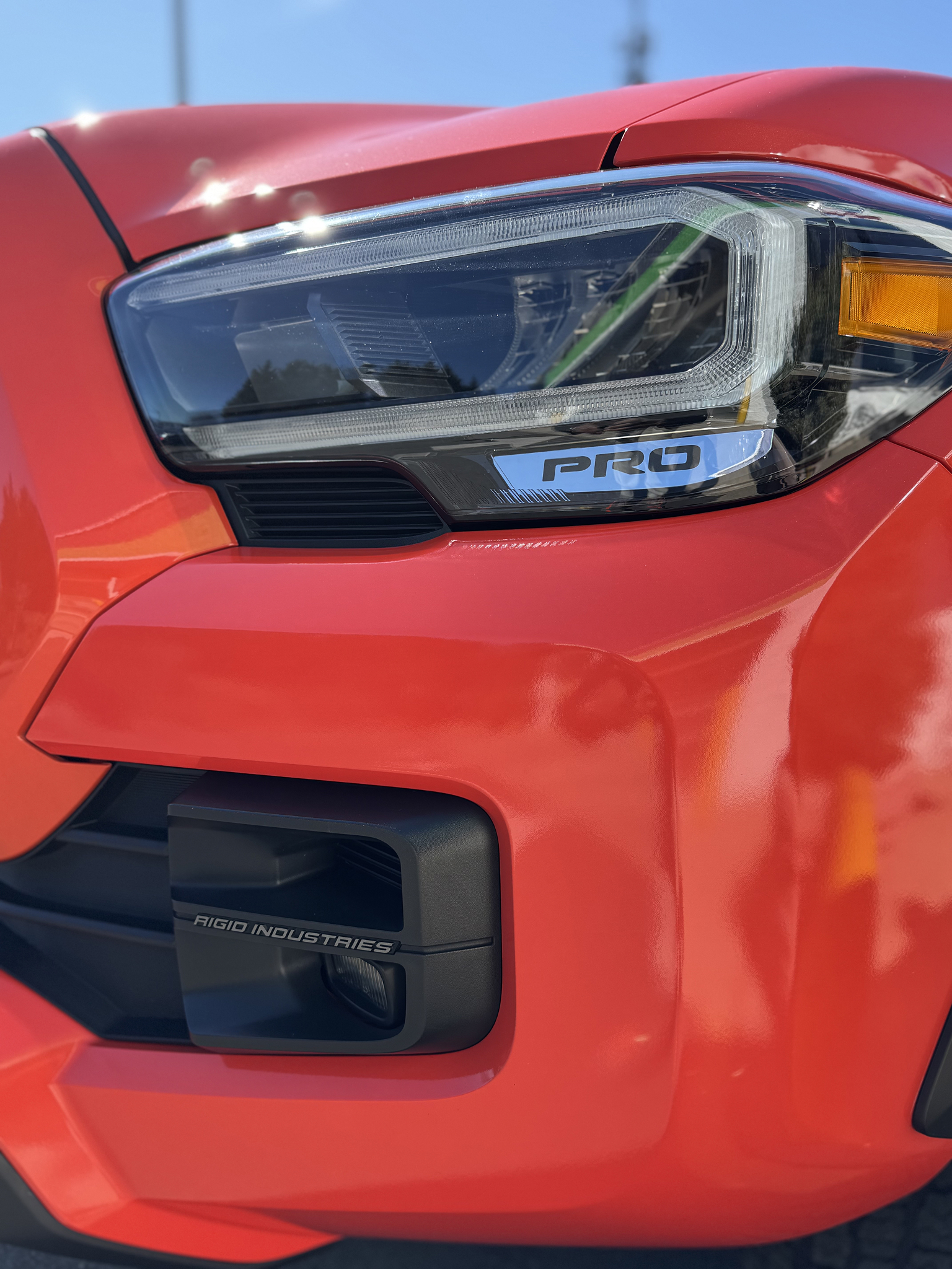 A close-up photo of a bright orange pickup truck that received ceramic coating at Clean Car Wash and Detail in Fredericksburg, VA.